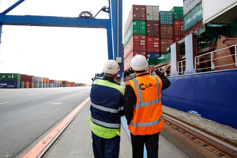 Two people at the dock making sure the loaded containers are ready to be shipped by sea